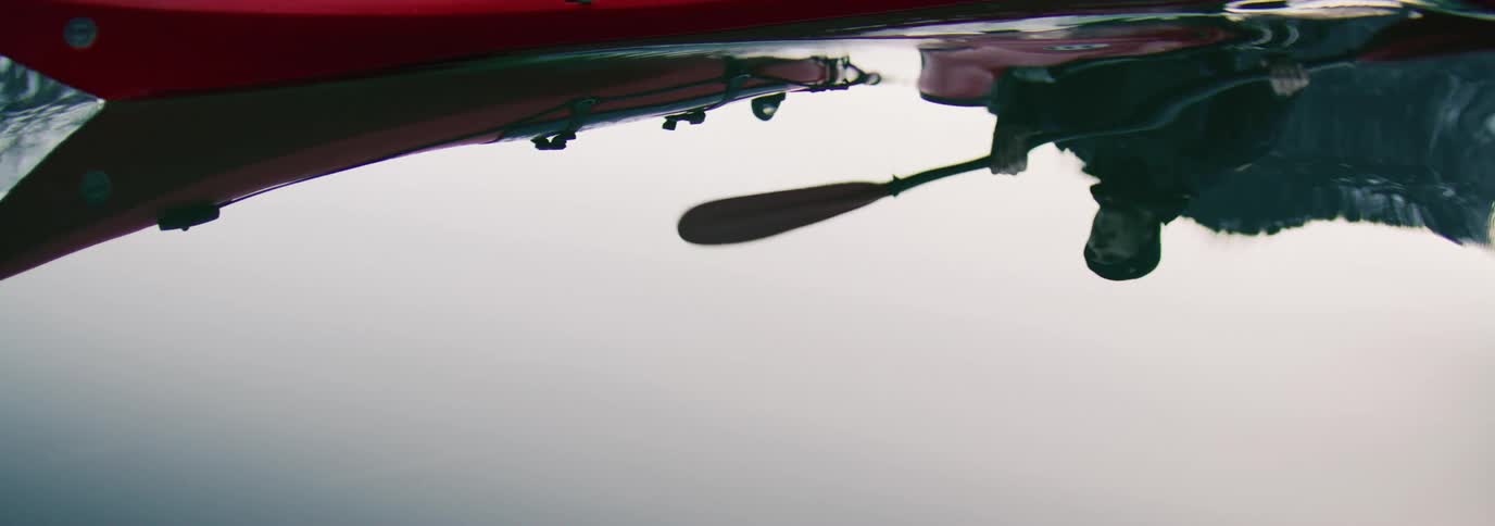 Man in a red kayak on a calm lake