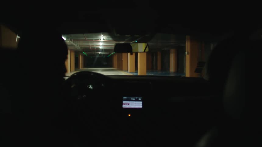 A person is driving out of the parking garage