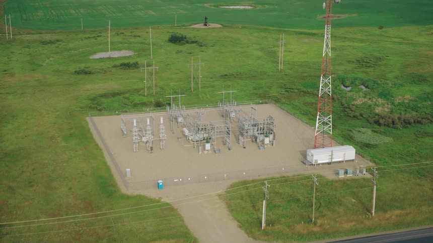 An electric power station sits on a grassland by the side of a road