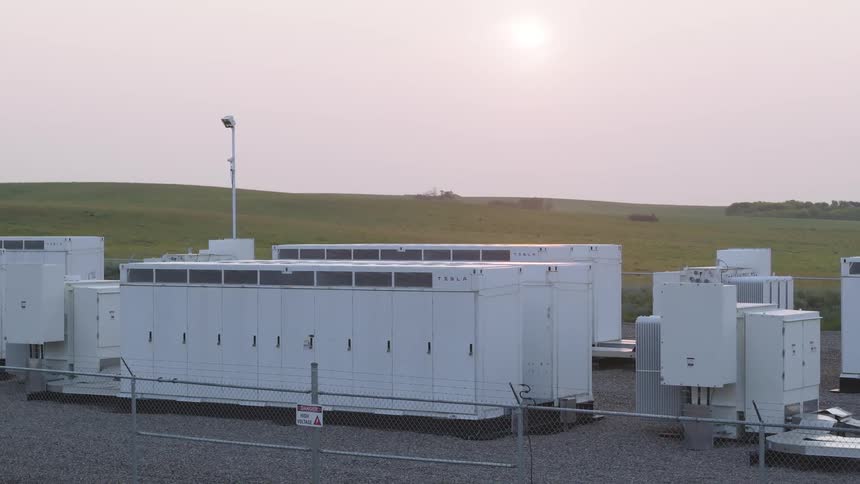 Batteries at a power station in a fenced area on an overcast day