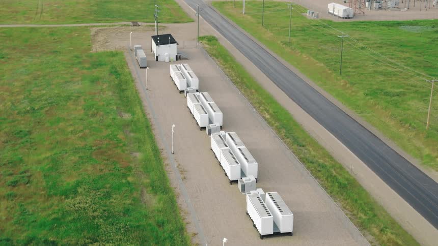 An aerial flyby of a battery grid storage system in summer