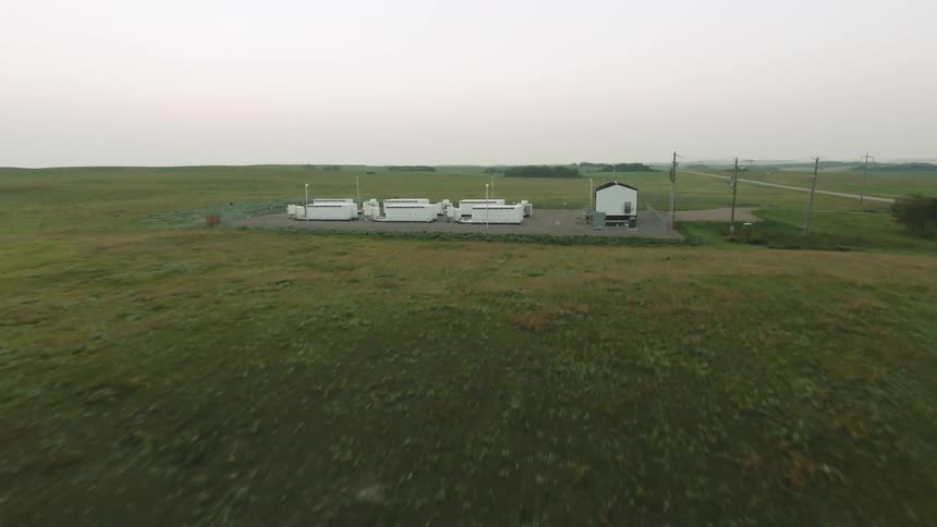 Aerial flyby of electrical battery equipment in the countryside