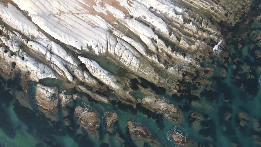 A white substance on rocks along a coastline