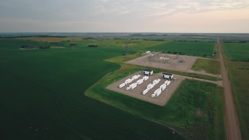 An aerial view of a large industrial electrical units surrounded by green agricultural fields