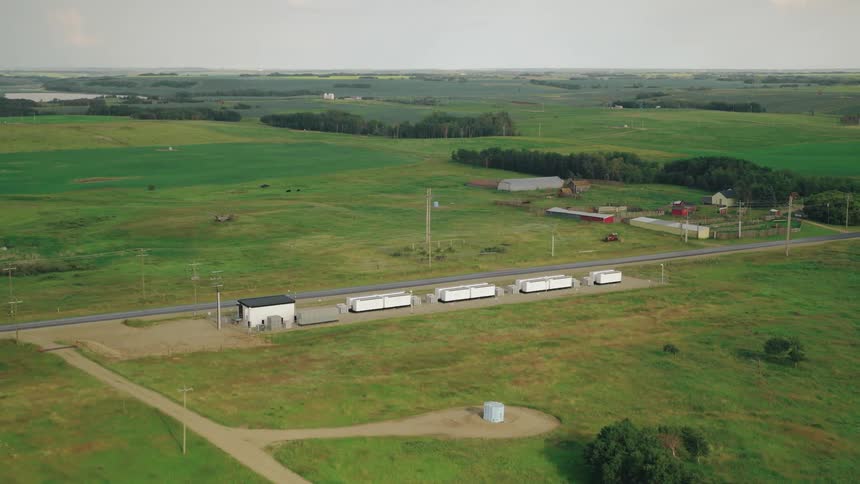 A large rural area of grassland with a megapack battery installation