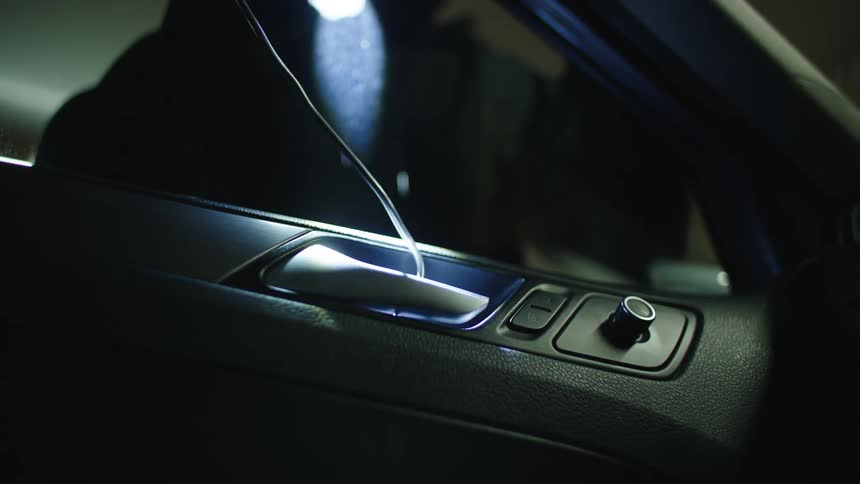 One thief opens car with a wire while the second criminal holds the flashlight