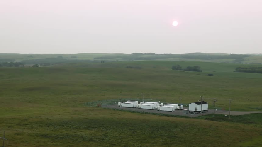 Aerial panorama of a battery backup system in the middle of a field in the morning