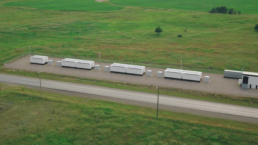 Battery backup cabinets sit idly in a large grassy field