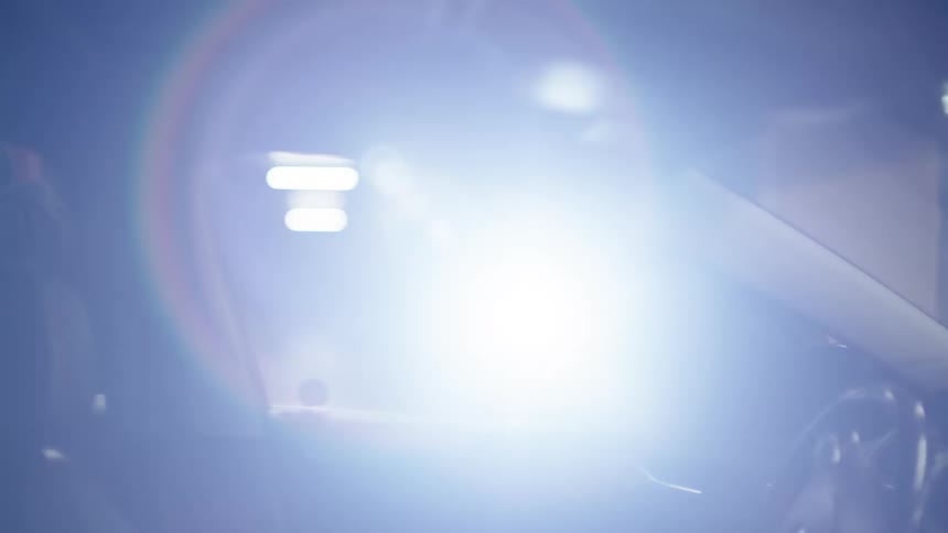Two thieves with a flashlight checking a car in a garage
