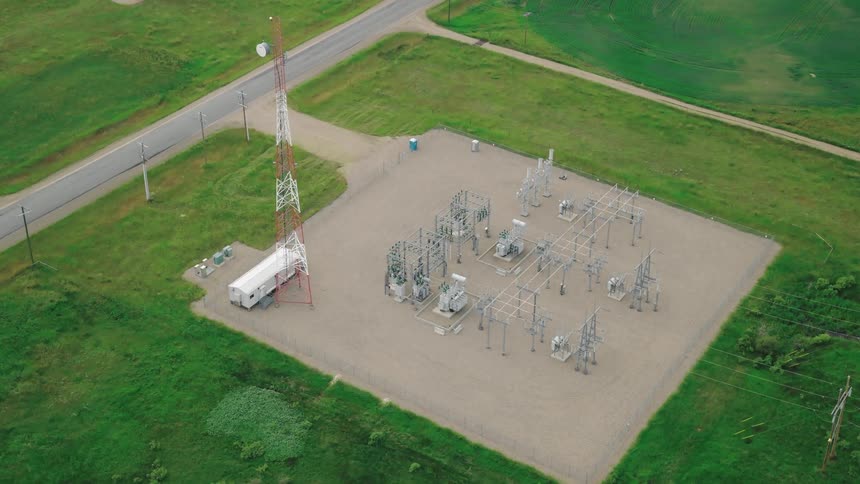 Aerial view of a communications tower and substation in a field