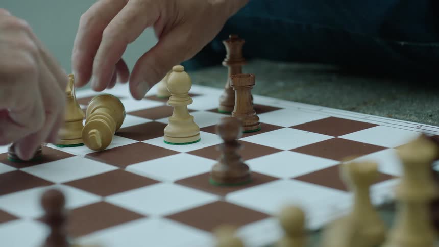 Closeup of two peoples hands playing chess