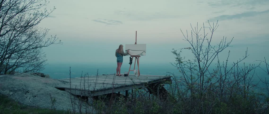 Woman in a natural environment on a mountain painting a picture