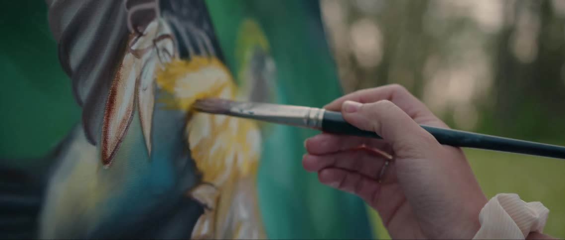 A woman is painting outside
