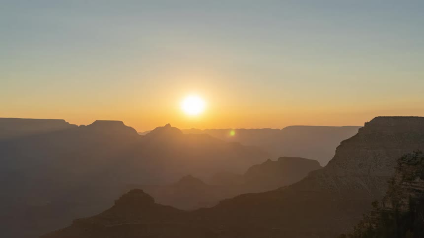 The sun rises over the grand canyon mountains