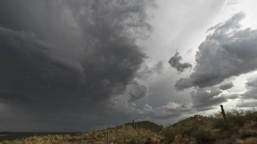 Time lapse of storm clouds rolling over a barren desert landscape