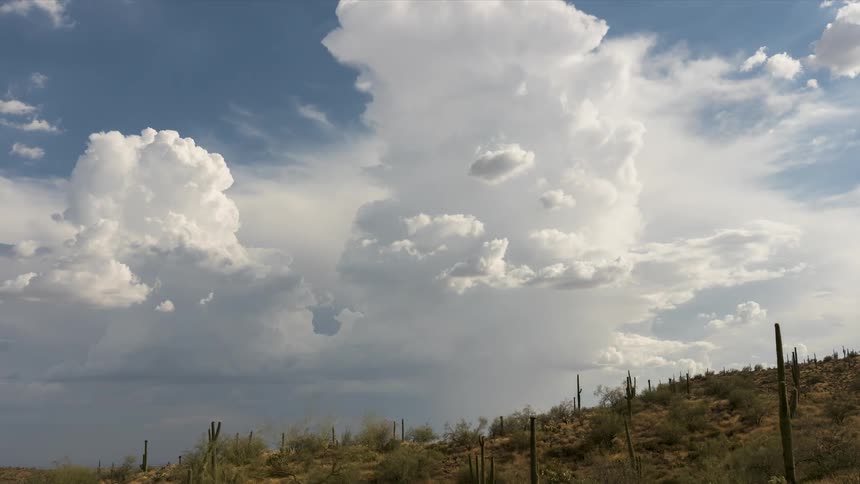 A sky with large white clouds moving quickly