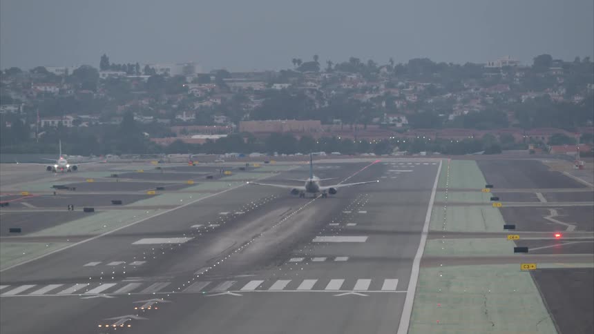 An airplane is taking off on a runway in the city