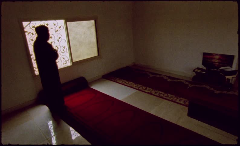 Man walks into a room and stands on the rug by a decorative window