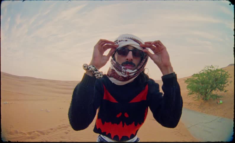 Man in the desert putting a cloth to cover his face