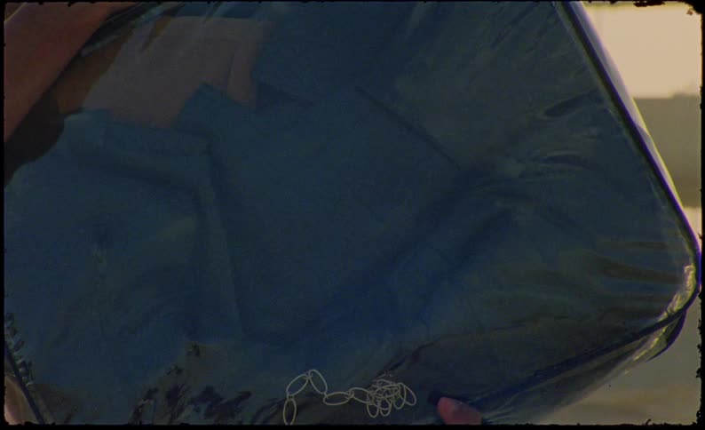 A man standing there is holding a bag full of clothes and a chain inside