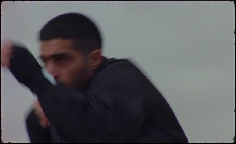 Man in an openair environment punching the air in a boxing movement