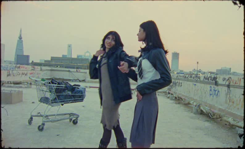 Two girls wearing schoolgirl uniforms modeling on the roof of an abandoned building