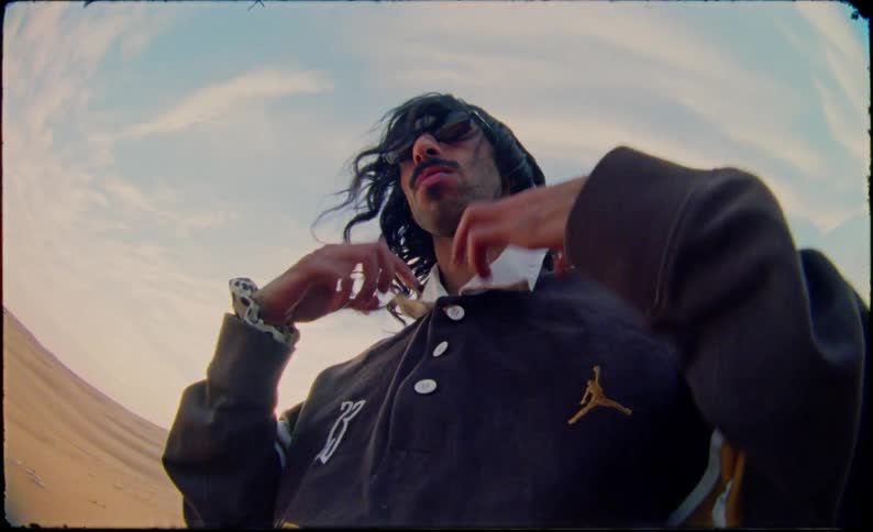 Man with a blouse and sunglasses in a desert environment