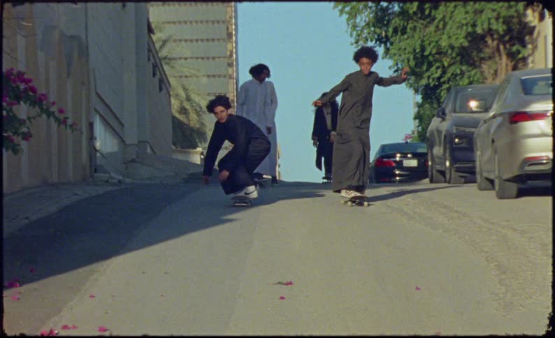 Boys and girls skateboarding down a street