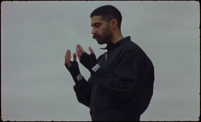 A man in black clothes is standing still and meditating