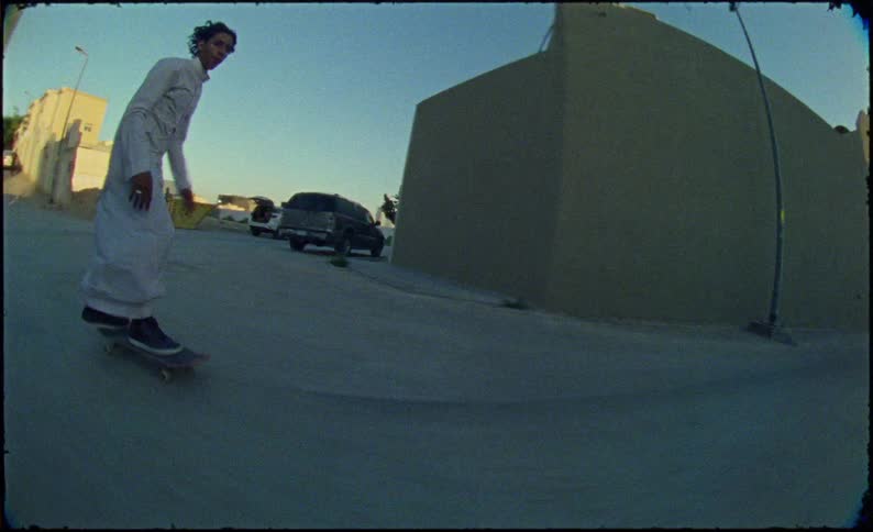 Teenagers skateboarding down a narrow street
