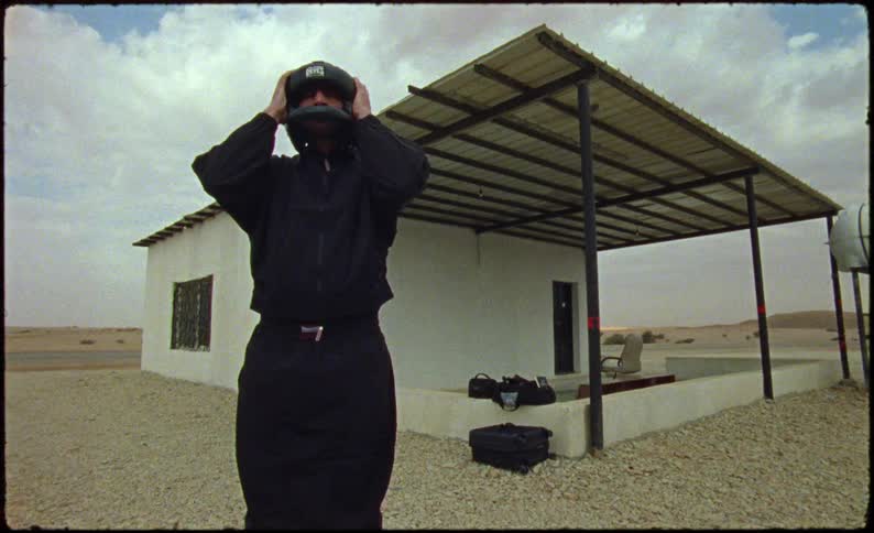 Man wearing an all black look and putting on a protective helmet