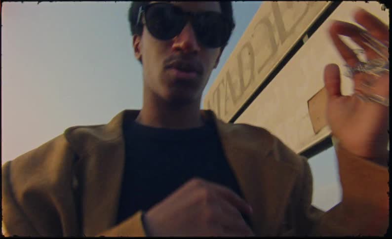 Portrait of a young smiling man holding a chain in his hands and wearing sunglasses
