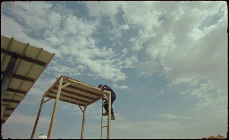 Man climbing the stairs of a tower and standing on top of it