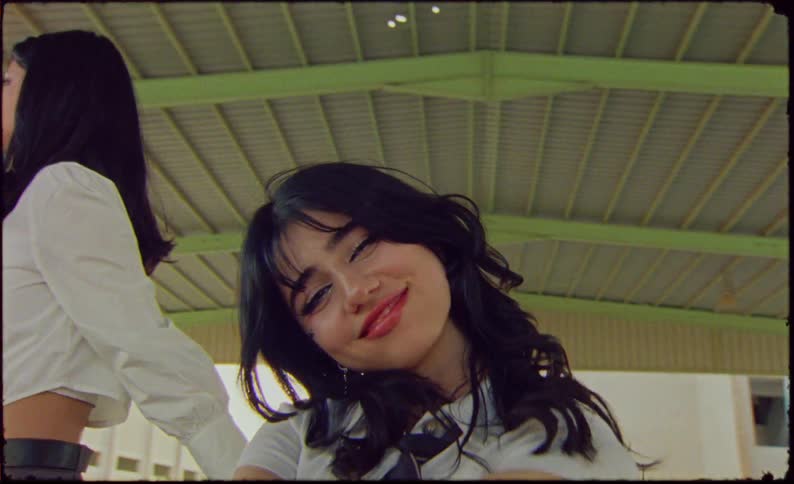 Two young female models in fashionable school clothes one of them inside a shopping cart