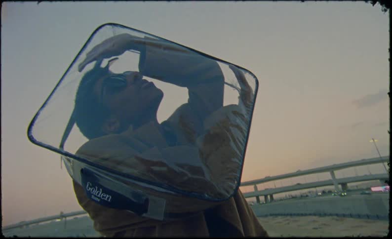 The man has his head and both arms inside a plastic square bag