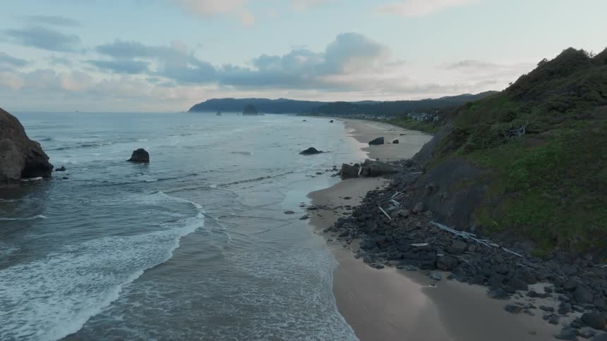 Aerial panorama of a beach with a rocky shore on a partly cloudy morning