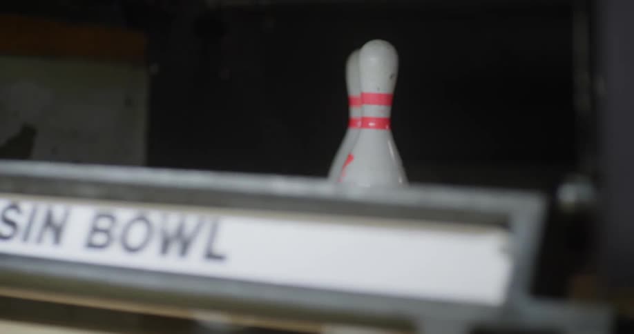 The bowling ball knocks over some pins