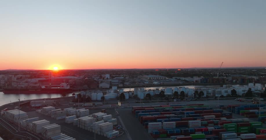 Shipping containers stacked in a port near a river and city