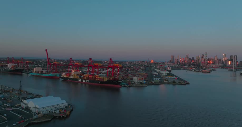 Aerial view of an active dock with multiple cranes and cargo ships