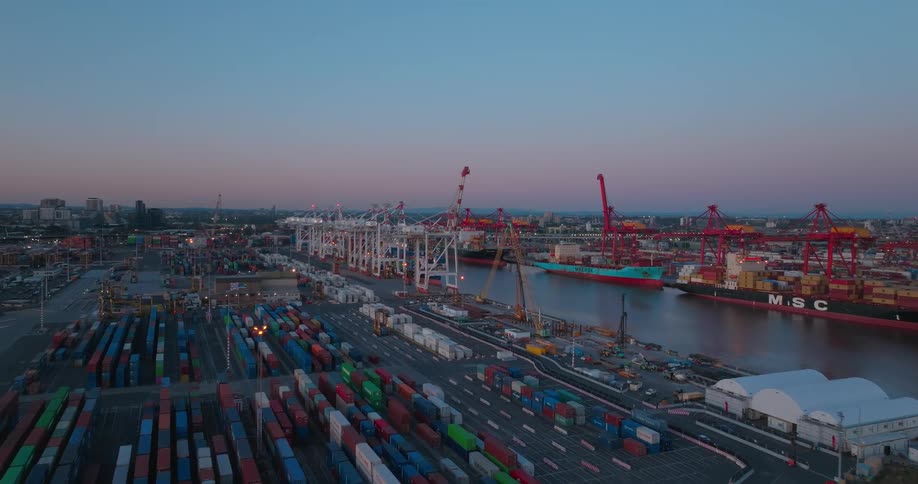 Aerial view of a loading dock with multiple cargo boats and containers