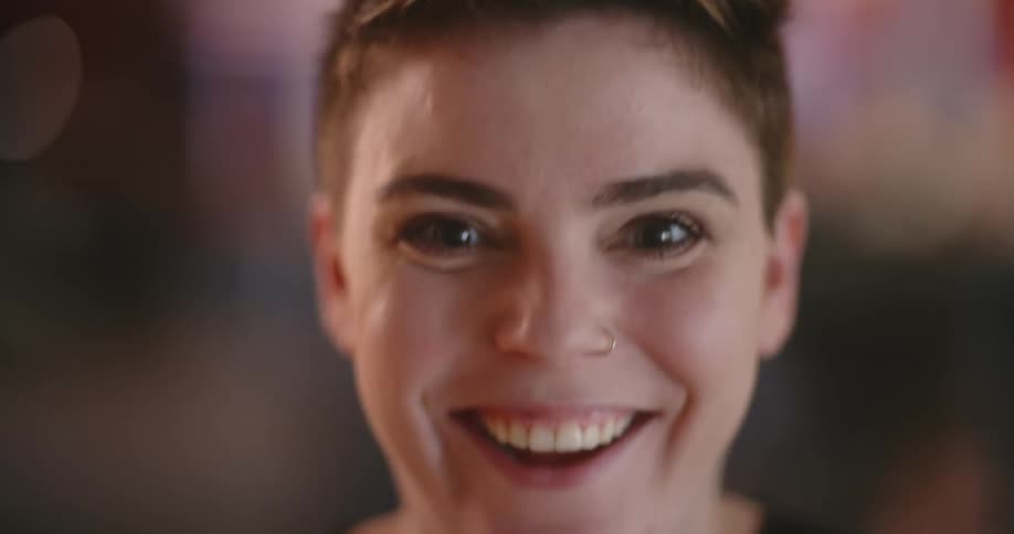 A woman jumps up and laughs
