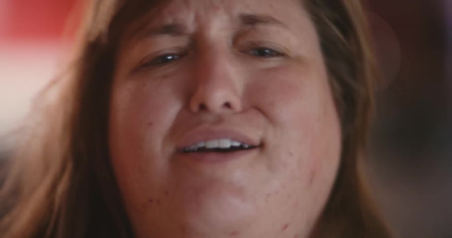 A woman stands up and raises her head with a disappointed smile