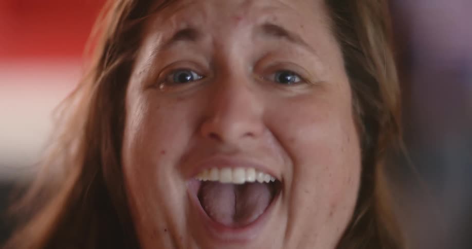 A woman jumps up and cheers