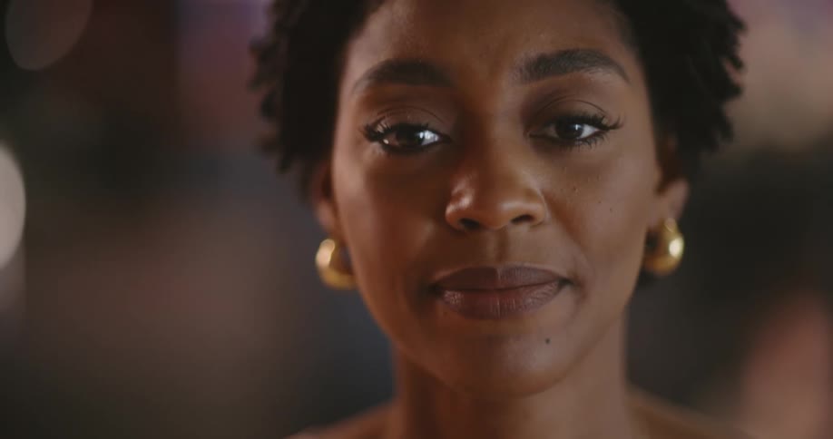 A black woman flinches and spits out a word in disappointment