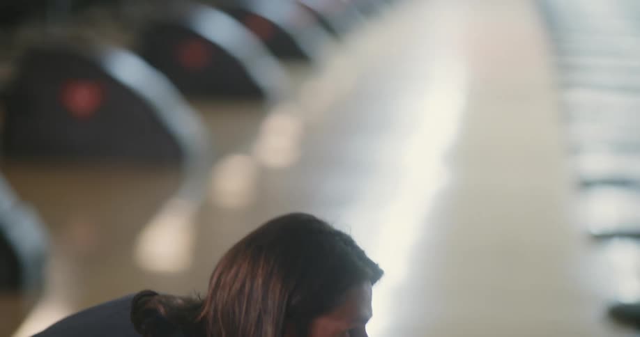Concentrated man throwing a bowling ball and his friends cheering in the background