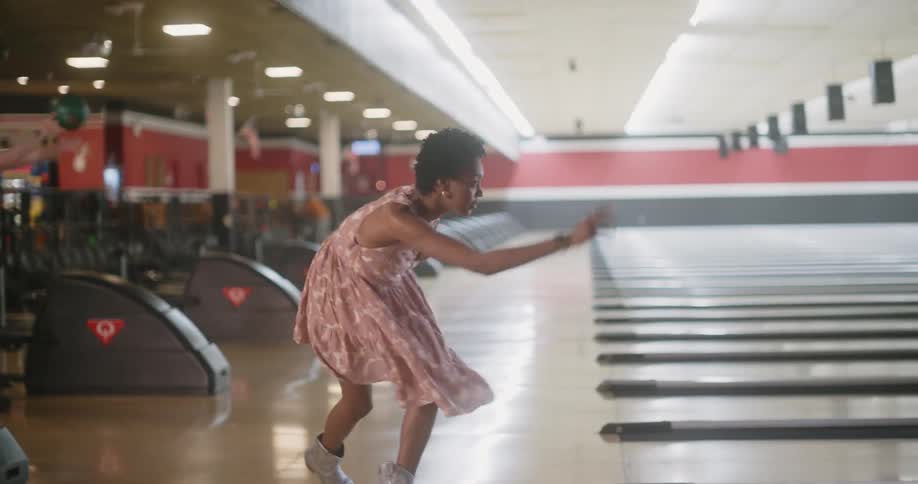 People sitting talking and two other women playing bowling