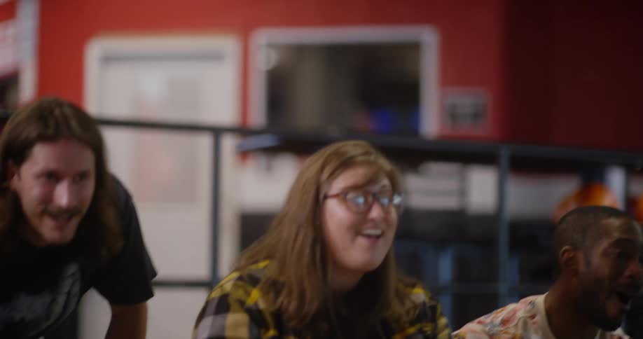 Woman concentrated with a bowling ball and then celebrating with her friends in the background