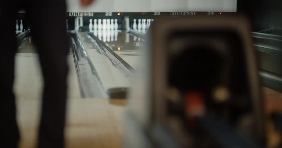 Person throwing a green ball in a bowling game