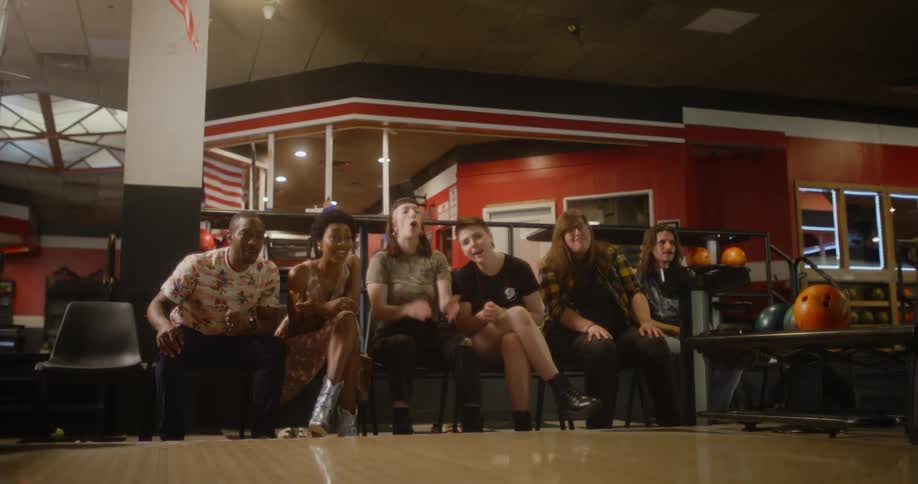 Friends cheer on a man as he bowls