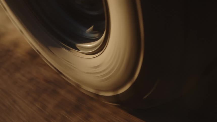 A closeup of a vehicles tire spinning on a dirt road